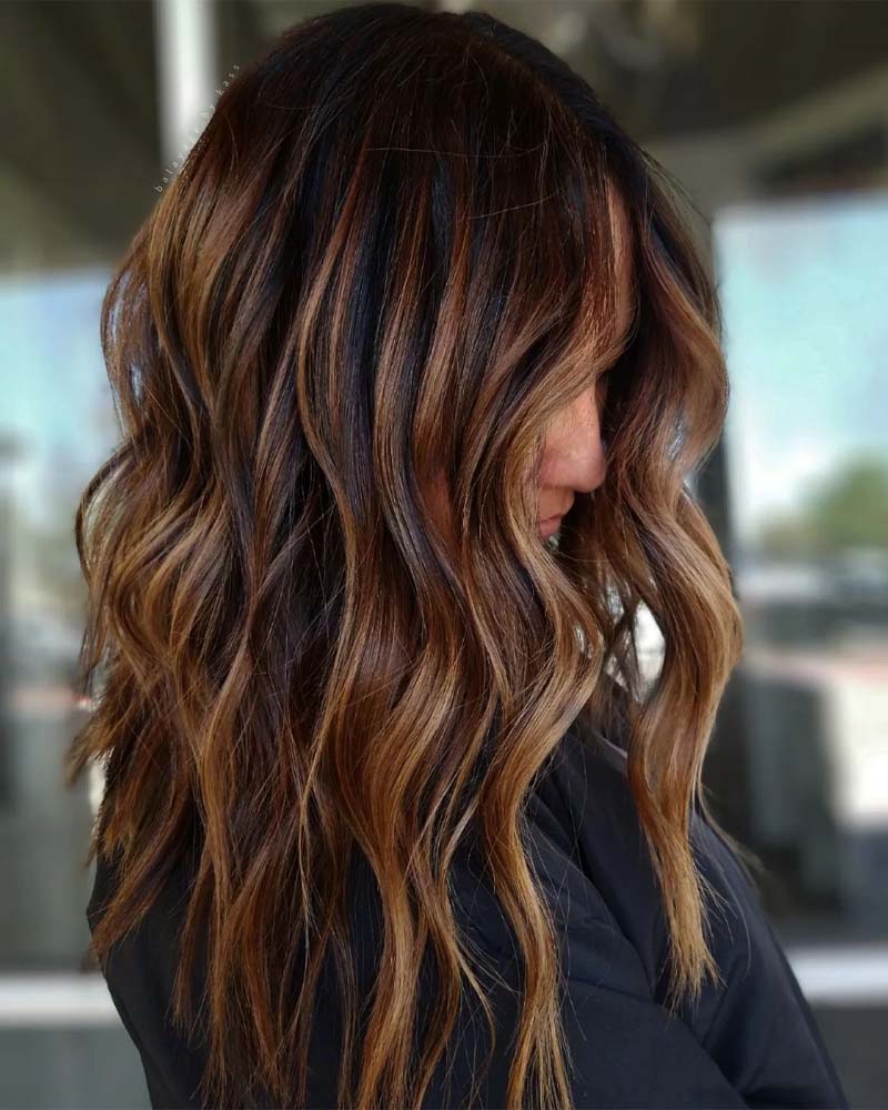 cheveux noirs avec reflets caramel - Luxe Digital