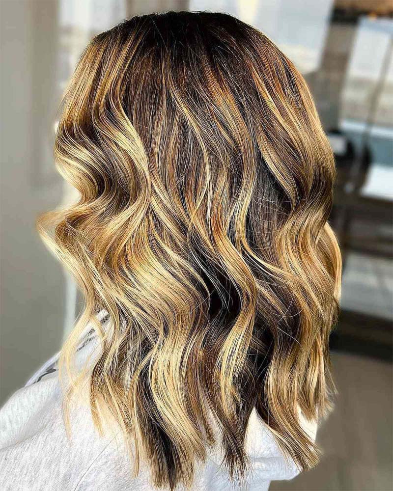 cheveux noirs avec des reflets blond miel - Luxe Digital