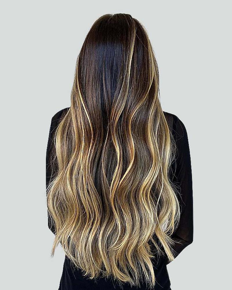 cheveux noirs avec des reflets blond miel - Luxe Digital