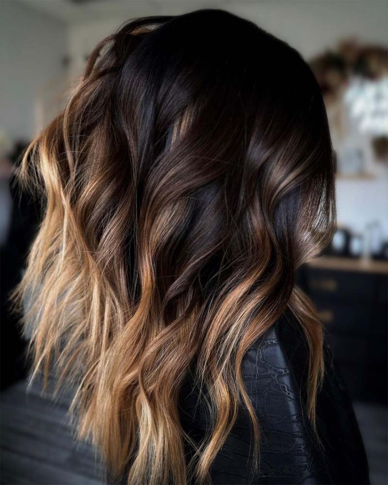 cheveux noirs avec des reflets blond miel - Luxe Digital