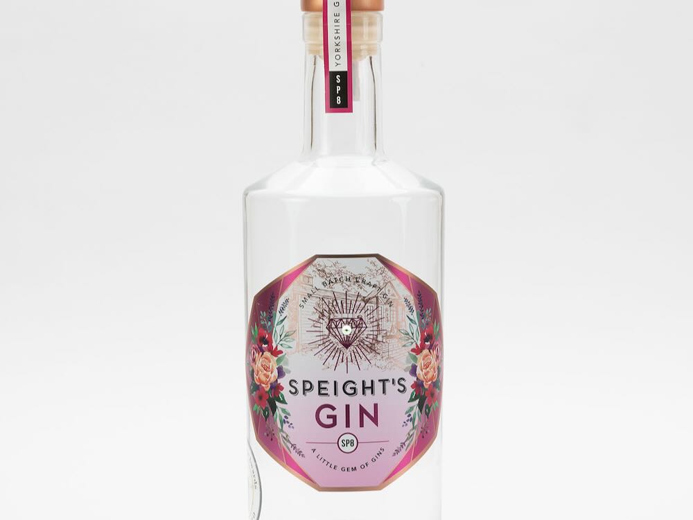 Bouteille de gin Speight avec une étiquette florale, célébrant les festivités de la Journée mondiale du gin.