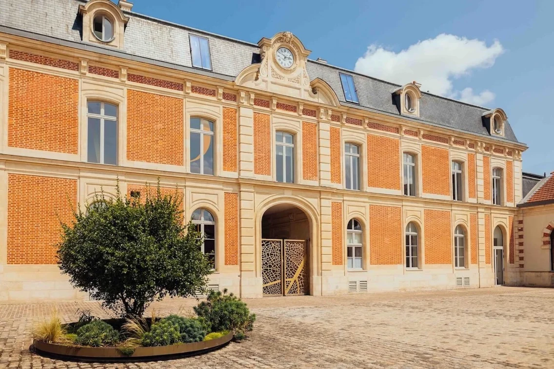 Le siège de Louis Roederer présente une élégante architecture en briques rouges et une cour paysagée.