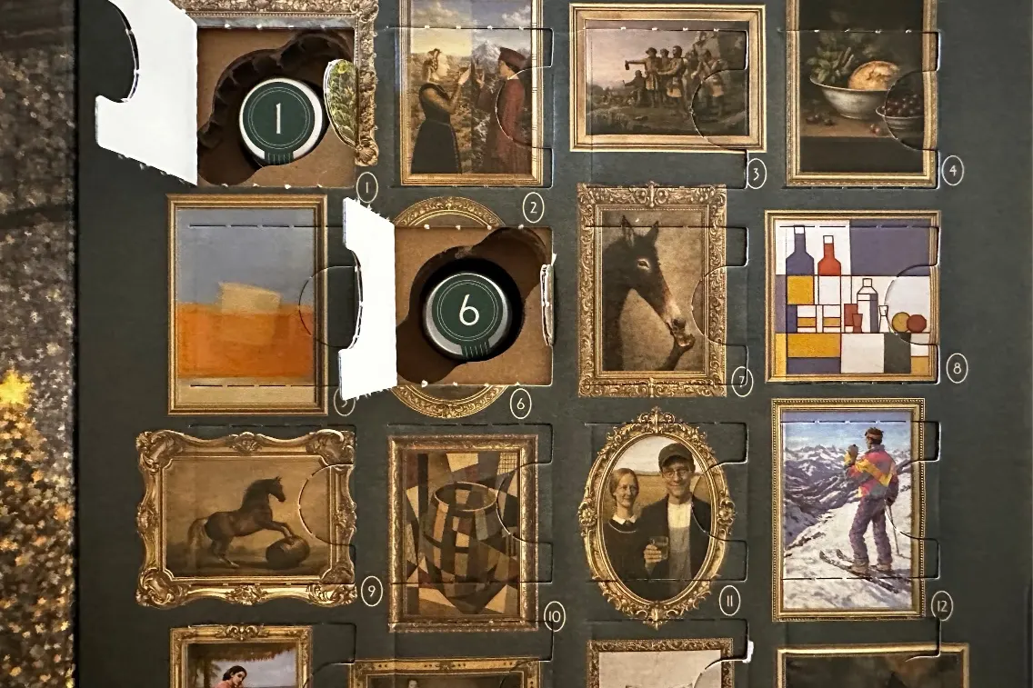Un calendrier de l'Avent avec divers cadres artistiques et une bouteille de whisky derrière l'une des portes, sur le thème des fêtes de fin d'année.
